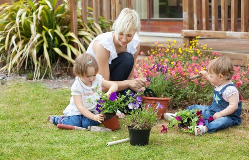 A gardener inspecting plants and taking notes during a site visit